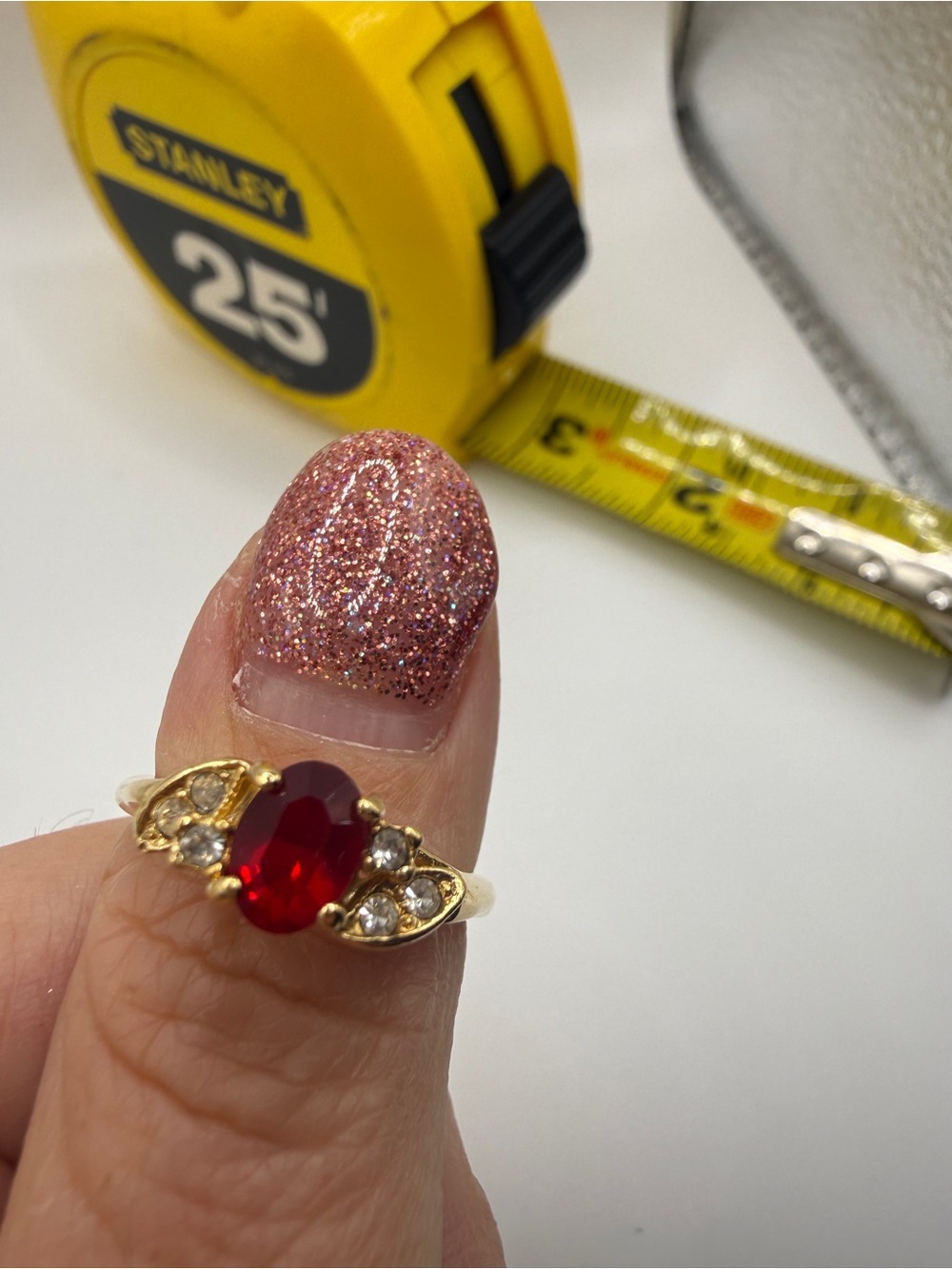 Gold Ring with Oval Red Center Stone and Clear Accent Stones